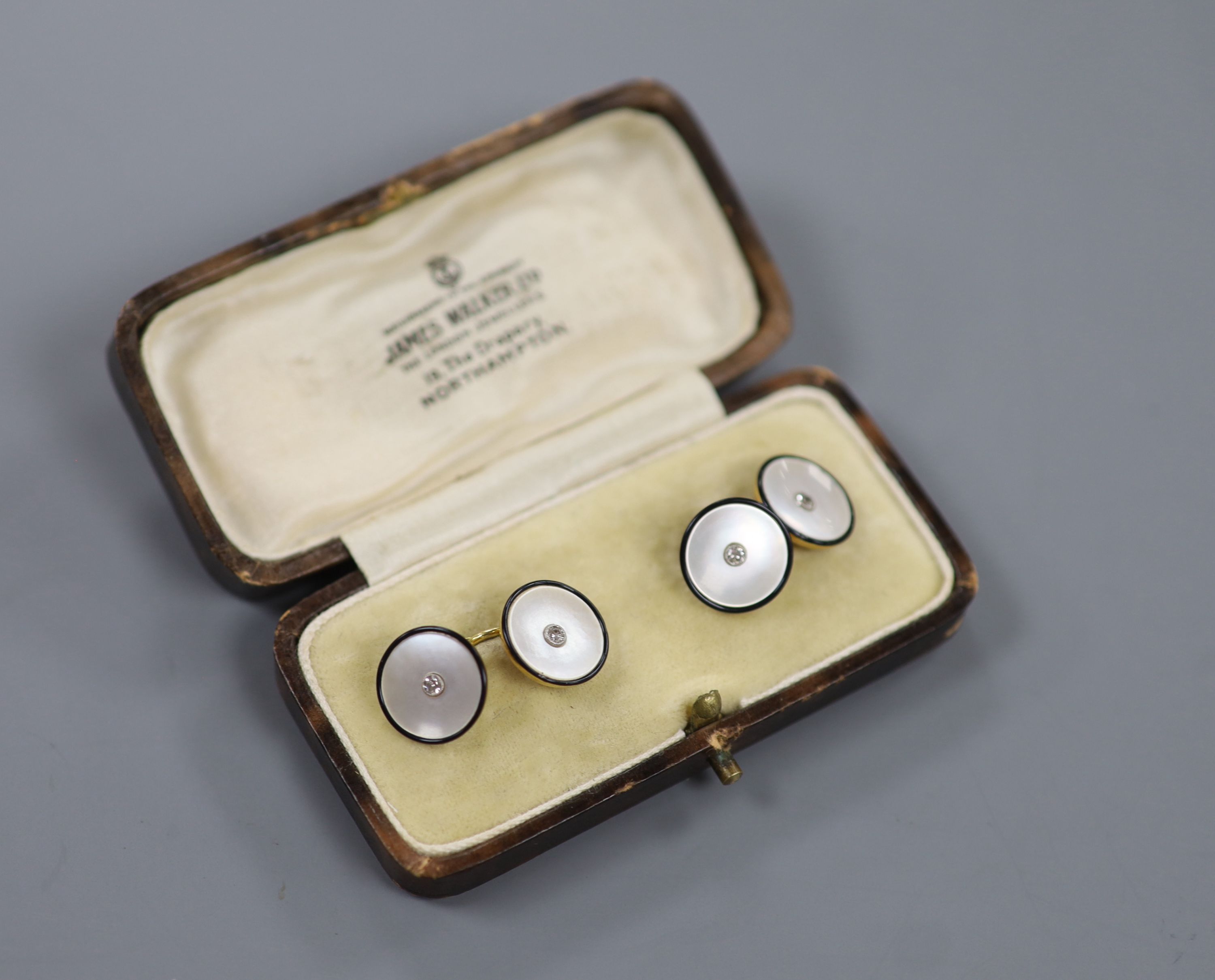 A cased pair of 18ct, mother of pearl, black enamel and diamond set circular cufflinks